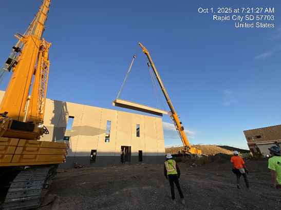 Cranes lowering a structure onto foundation